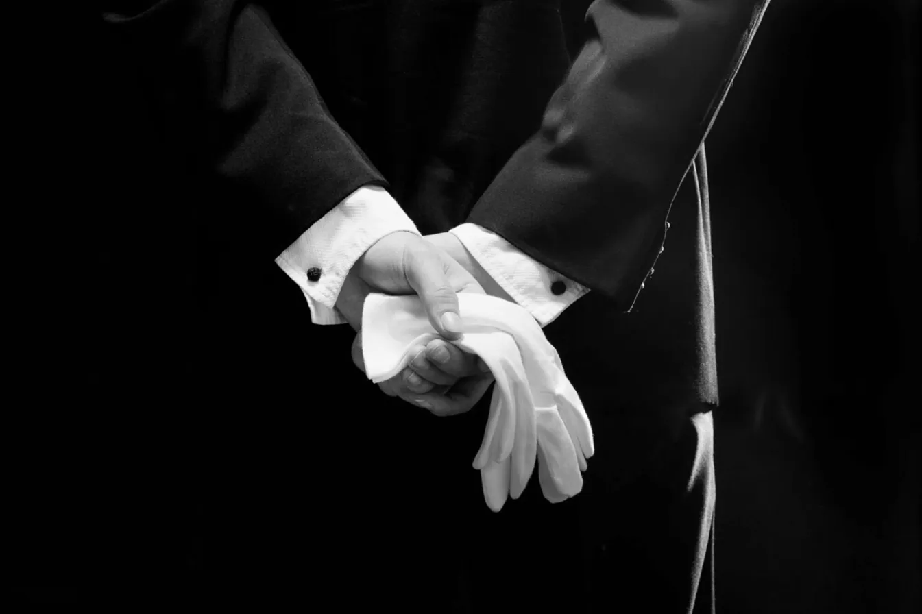 Gants blancs tenus avec précision, métaphore des standards et de la discipline de marque