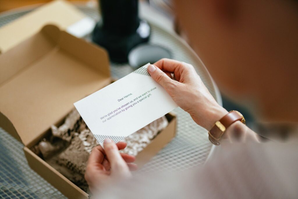 Mains tenant une carte de visite premium déballée d'un coffret de présentation