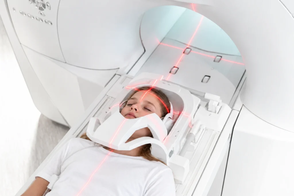 Jeune patiente allongée dans un scanner médical avec laser de positionnement