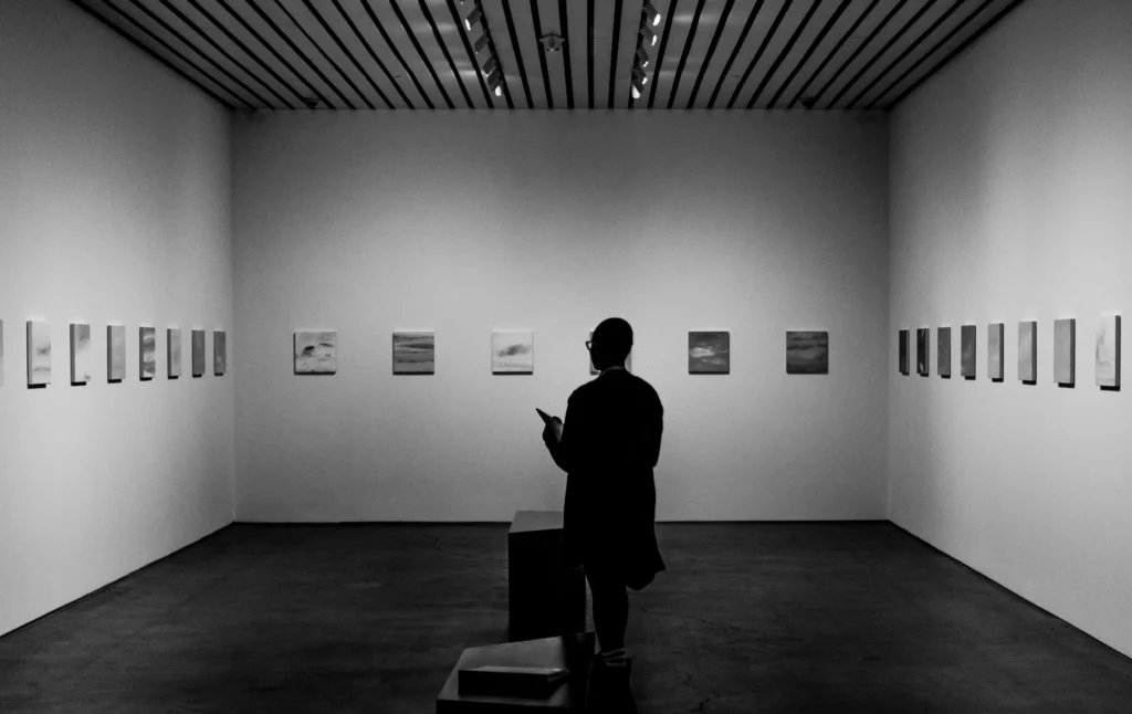 Visiteur face à une série d’œuvres, métaphore du choix et de la différenciation